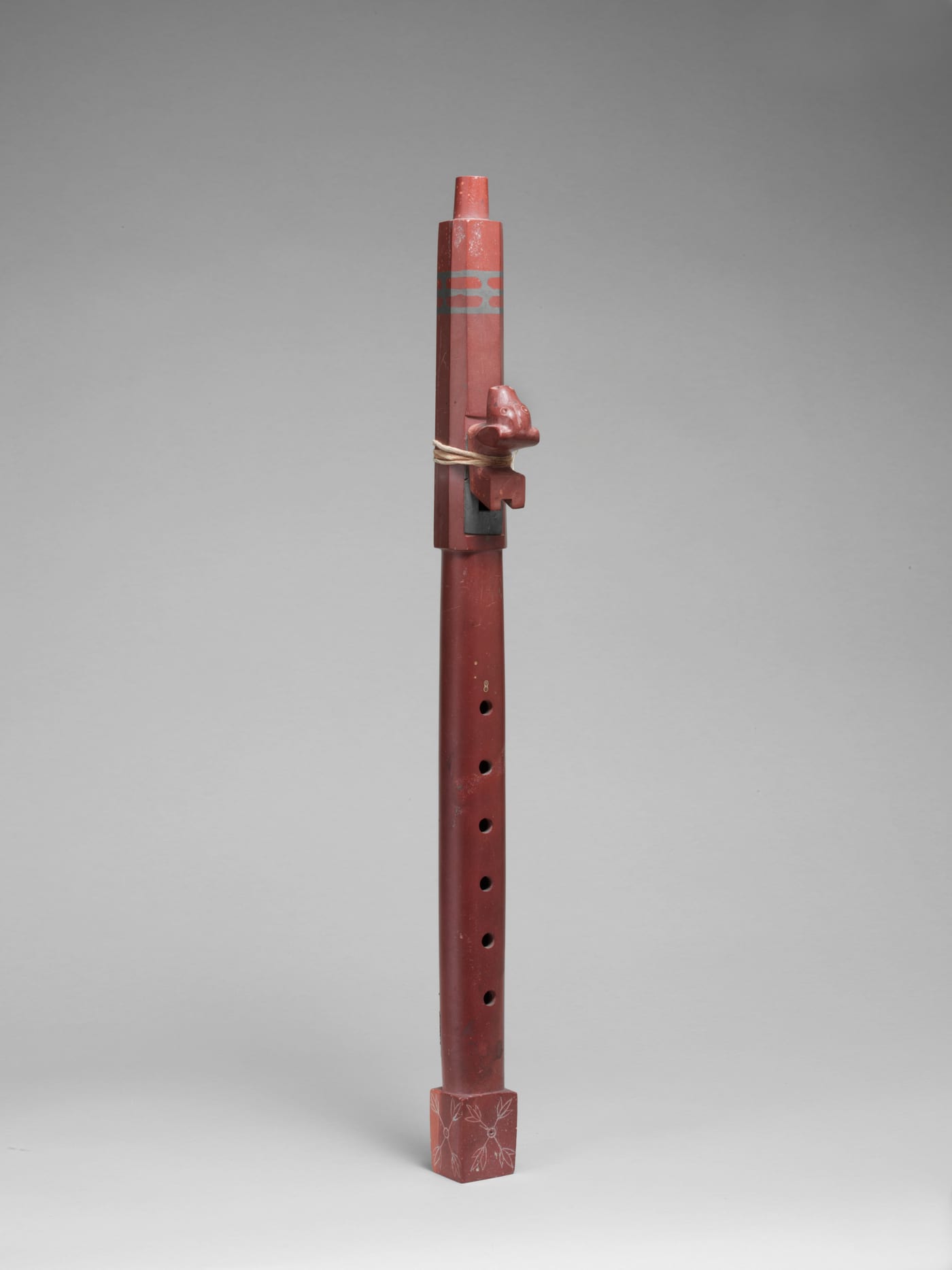 Sioux courting flute (siyotanka) carved from red pipestone (catlinite), ca. 1850 to 1900, with a carved animal figure at the sound hole.