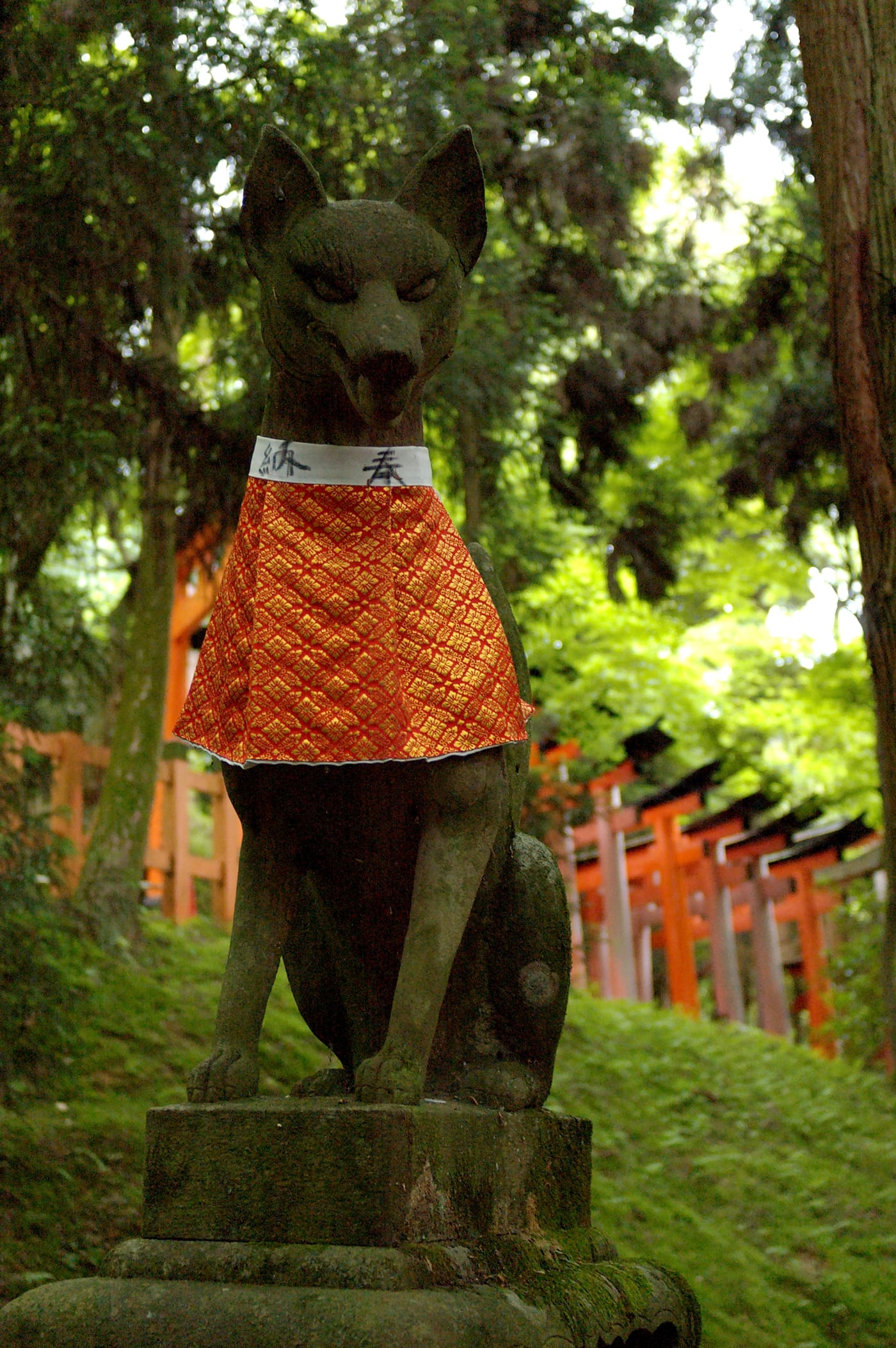 Stone fox (kitsune) statue flanking the entrance to Fushimi Inari shrine, Kyoto.