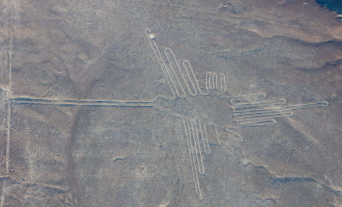 Aerial photograph of the Nazca Hummingbird geoglyph on the Nazca Plateau, Peru, 300 BCE to 500 CE, showing the approximately 93-meter-long outline of a hummingbird drawn in the desert surface.