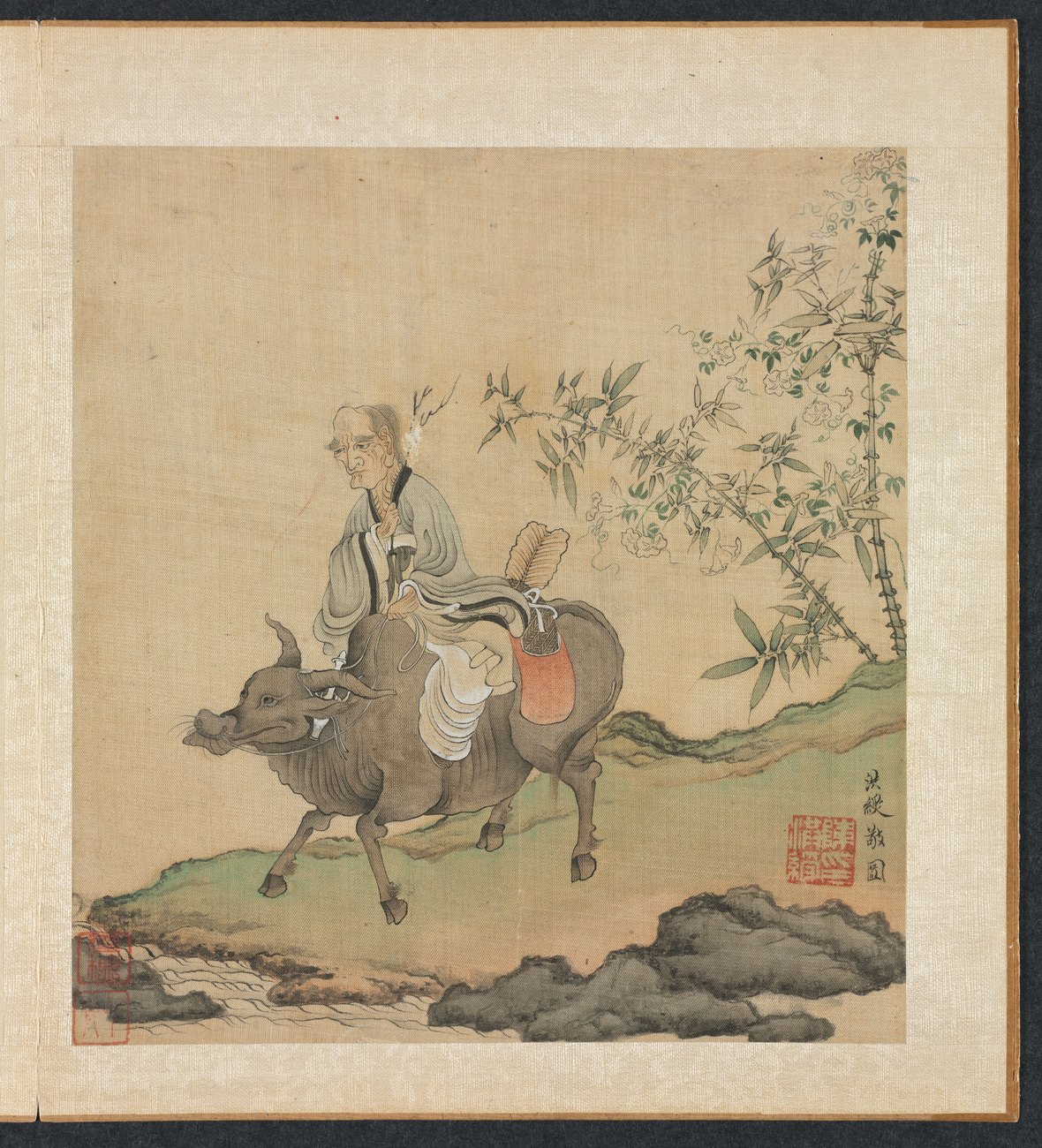 Ming dynasty ink and colour album leaf of a bearded old man in robes seated on the back of an ox beneath an overhanging branch, with a red seal at the upper right.