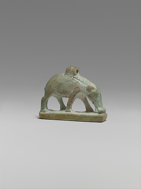 Small pale green Egyptian faience amulet in the shape of a standing sow on a rectangular base, about three centimetres long.