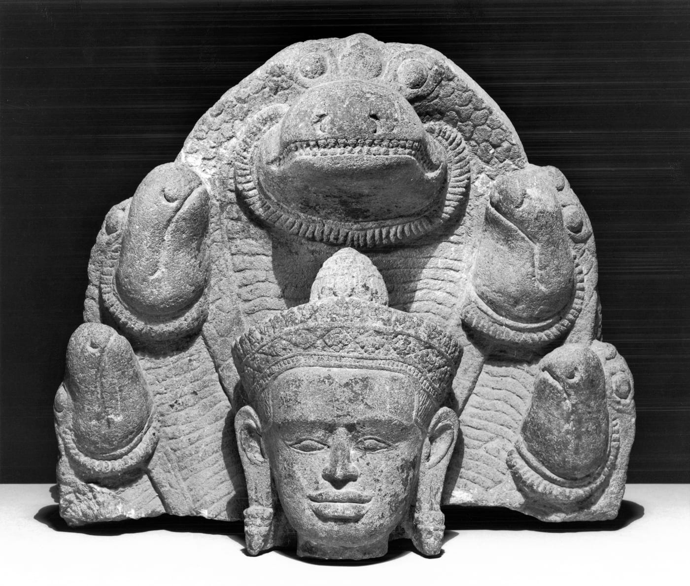 Stone carving of the seven-headed nāga Mucalinda sheltering the meditating Buddha during a storm, Khmer period, 12th century CE, Angkor Wat, Cambodia.